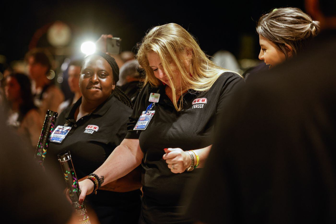 H-E-B worker Cindy Flach, left, dance next to they coworker Krissy Crump as they prepare to...