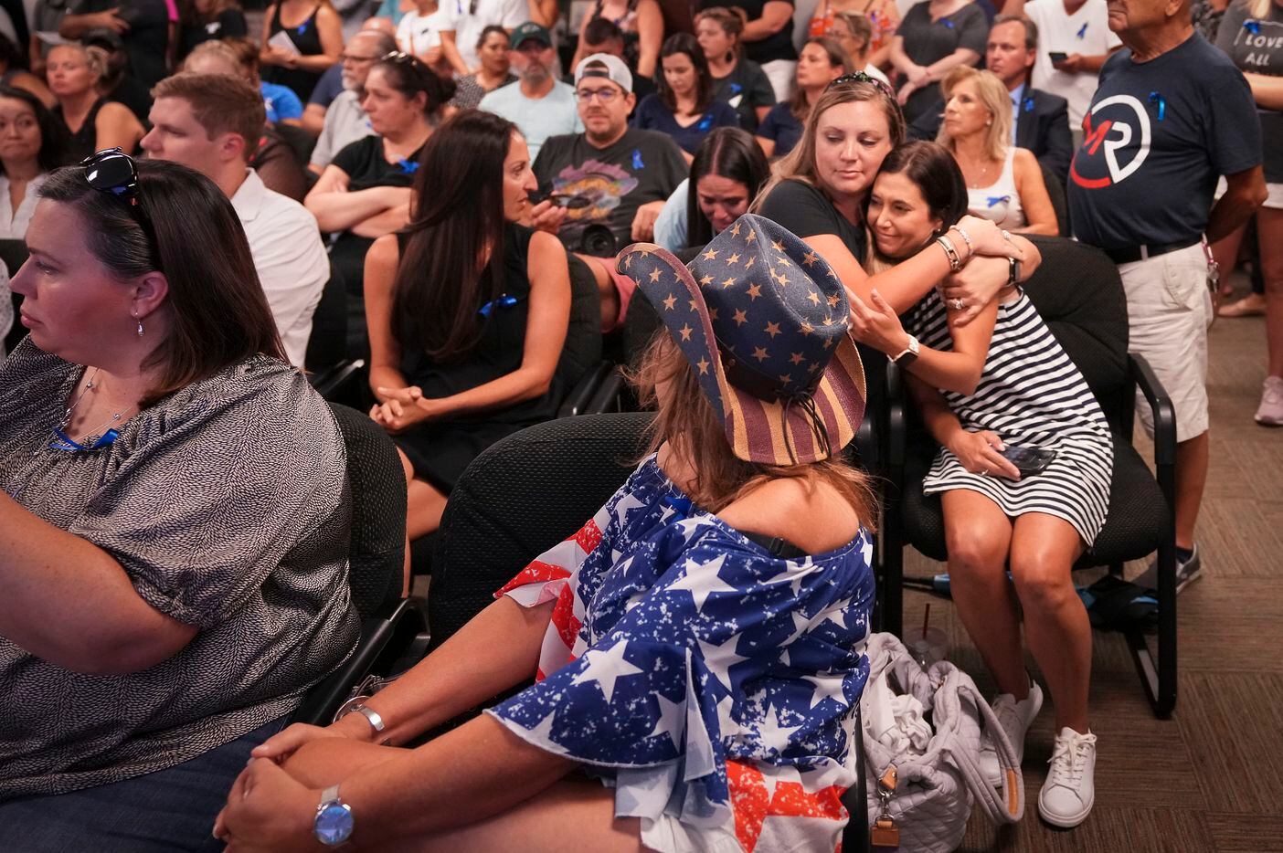 Lisa Cox (right) gets a hug of support from Ashley Machel after speaking during public...