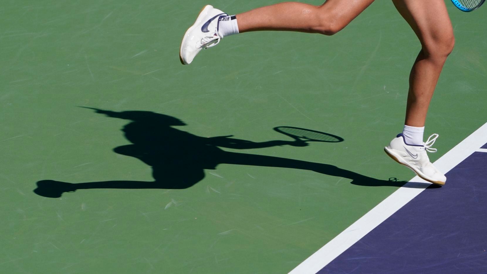 The shadow of a women's professional tennis player is shows during the BNP Paribas Open...