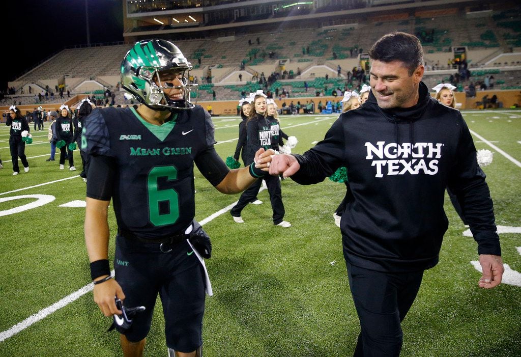 North Texas Mean Green head coach Seth Littrell fist bumps quarterback Mason Fine (6) on his...