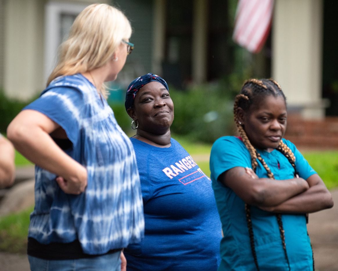 LaTasha Kelly, 39, center, reacts with a smile while speaking to friend Laquila Levy,...