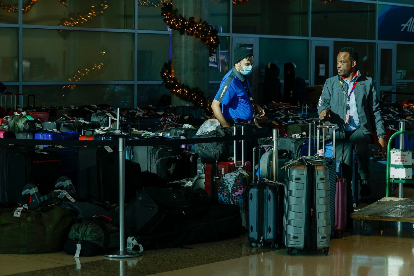 Southwest Airlines employees talk amongst hundreds of unclaimed checked bags at Love Field...