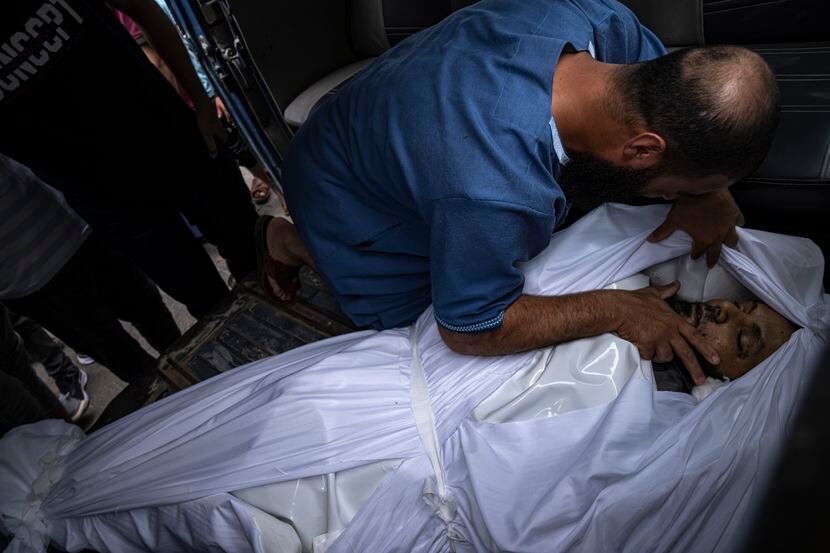 FILE - A relative mourns over a man killed in an Israeli air strike in Gaza City on Monday,...