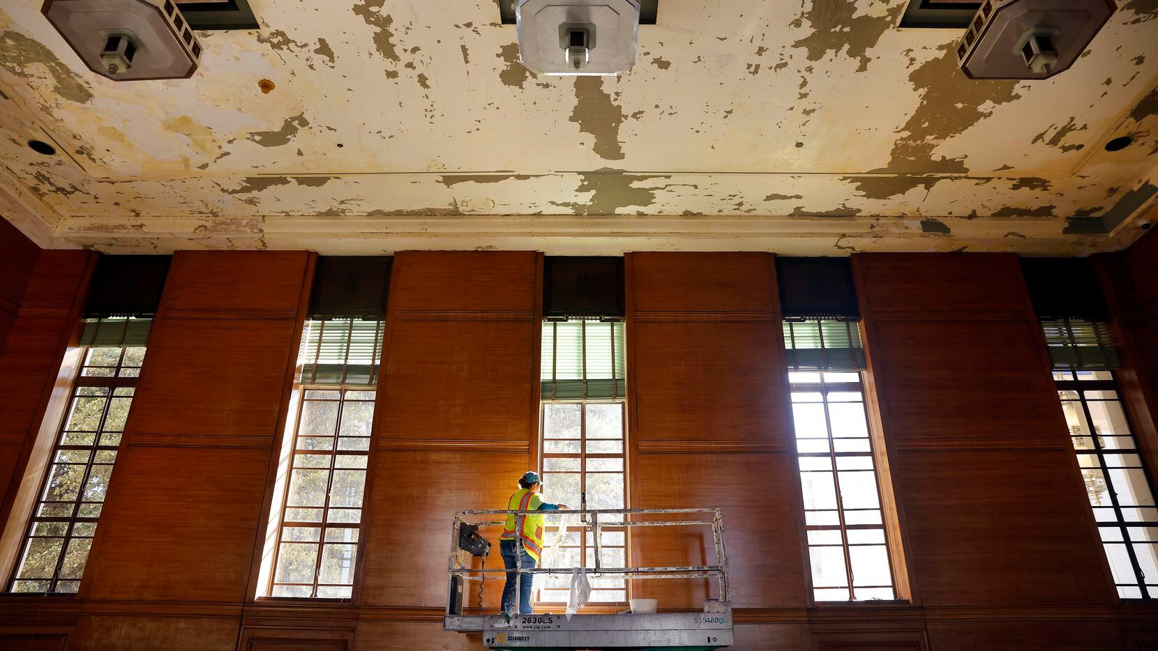 Contractors from Phoenix 1 Restoration have begun scraping loose paint in the East Texas Room where water damaged the Hall of State building at Fair Park in Dallas.