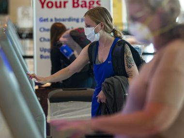 Mary McKenna of Dallas uses a Southwest Airlines kiosk at Dallas Love Field airport in Dallas on Sunday, July 26, 2020.