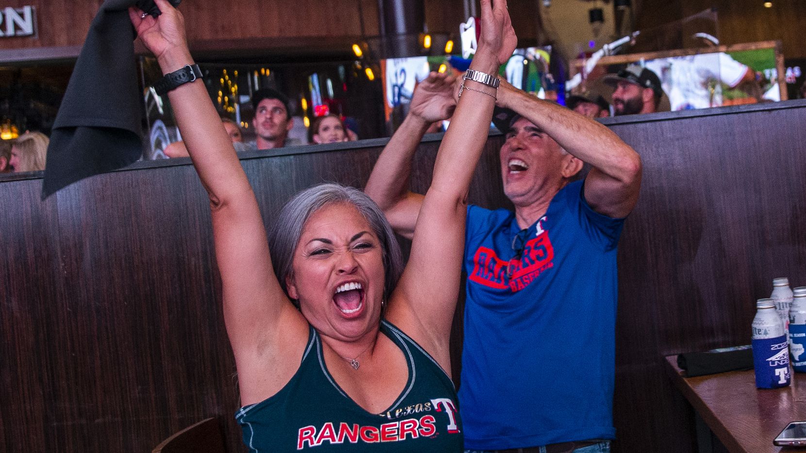 Claudia Borunda (left), from California, cheers with fans as the Texas Rangers win their...