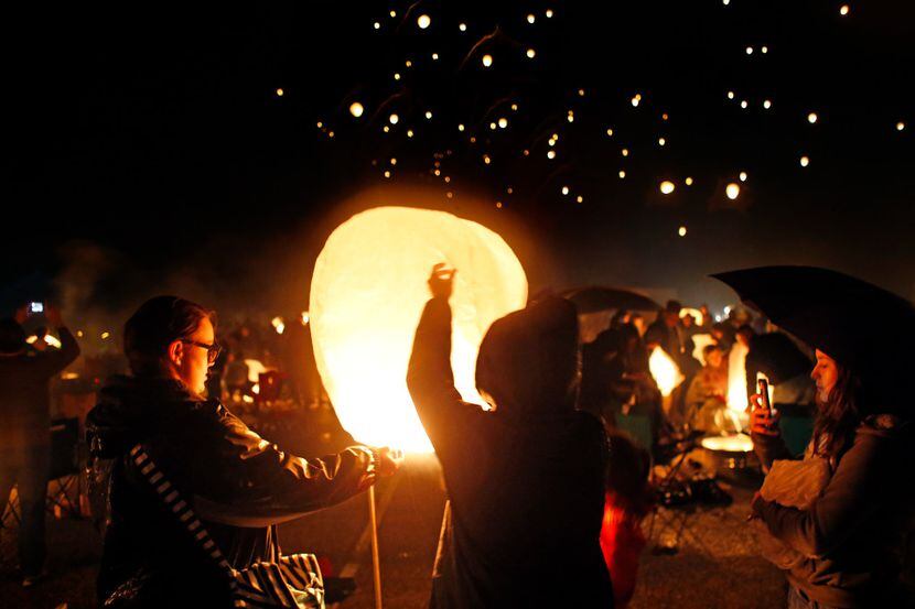 People light paper lanterns and release them at the Lantern Festival at Texas Motorplex in...