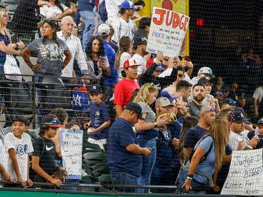 Fans hold signs before a MLB game between the New York Yankees and Texas Rangers at Globe...