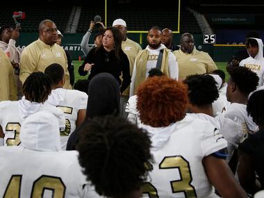 Dallas ISD Athletic Director Dr. Sylvia Salinas, center, delivers an inspirational post-game...