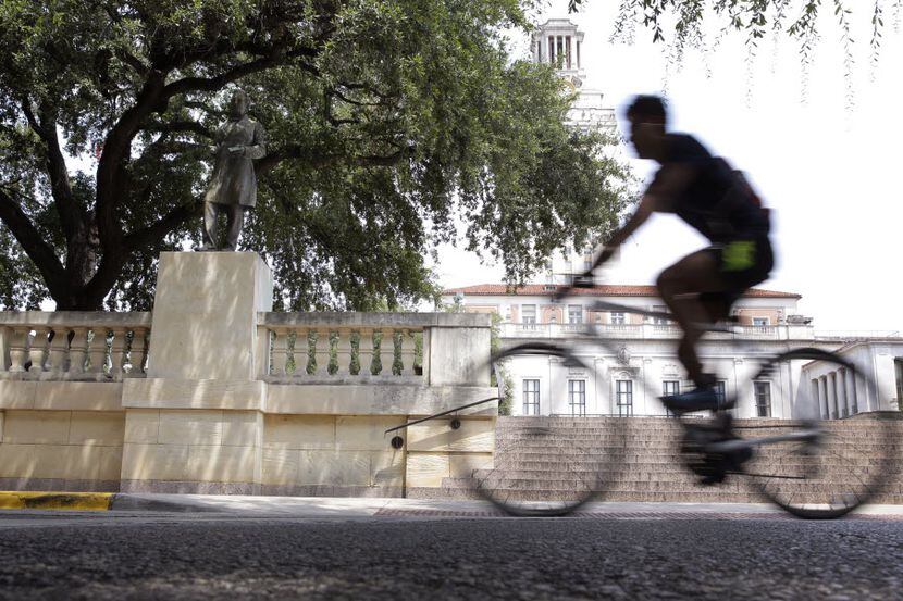 A cyclist passes a statue of Confederate President Jefferson Davis on the University of...