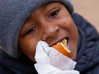 Donovan Morris, 4, eats his Fletcher's Original Corny Dog at Klyde Warren Park on Saturday,...