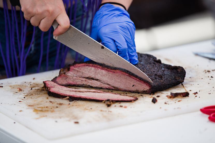 A student slices beef brisket at the State of Texas High School Barbecue Cook-off in Burnet.