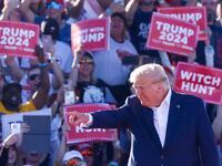 Former President Donald Trump points towards the crowd during his first 2024 campaign rally...