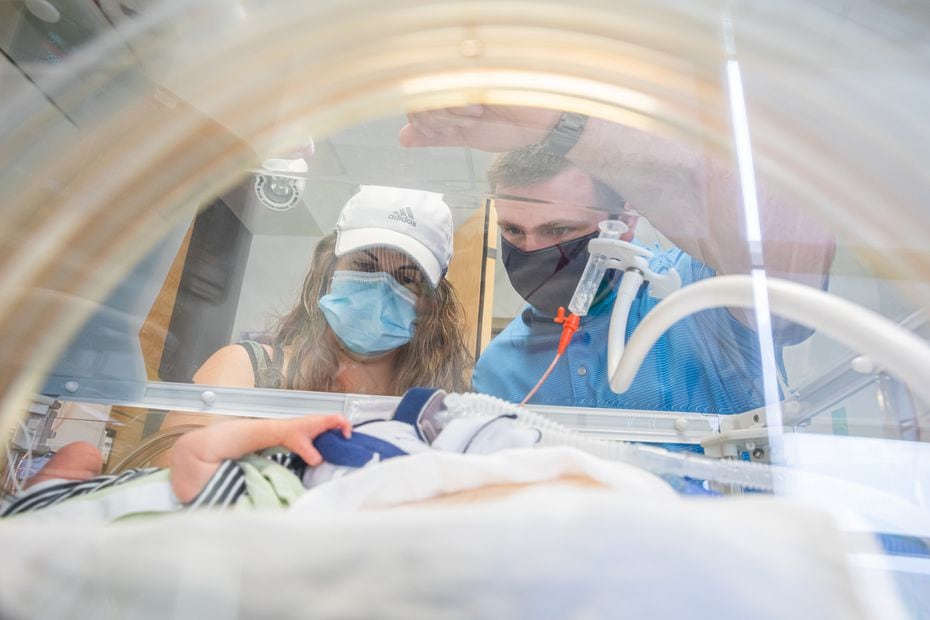 Katie and Chris Sturm view one of the quadruplets in the neonatal intensive care unit. Courtesy of UT Southwestern.