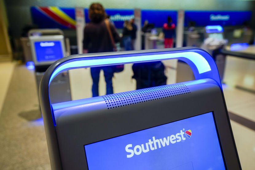 Pasajeros en la lista de espera para etiquetar su maleta y volar en Southwest Airlines,...