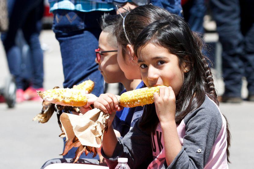 Three little girls get pulled around in a wagon while they eat their corn at Traders Village. 