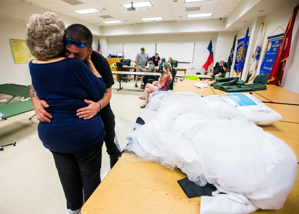 Joyce Brown, office manager of the Lumberton Central Fire Station, hugs firefighter Kyle Parry, who retrieved the wedding dress of his fiancee, Stephanie Hoekstra, from his flooded house. 