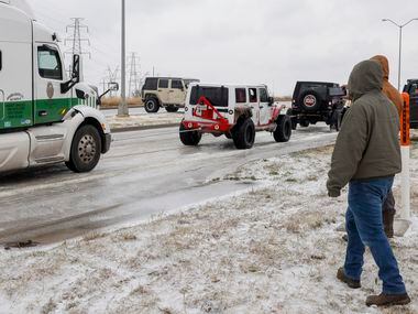 Carnales Off Road Jeep club members watch as other members pull a stuck semi-truck up an...