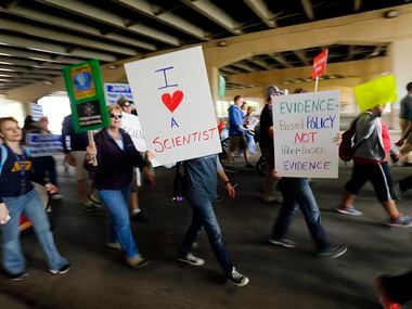 March For Science supporters march under Interstate 30 on their way to Fair Park's Earth Day...