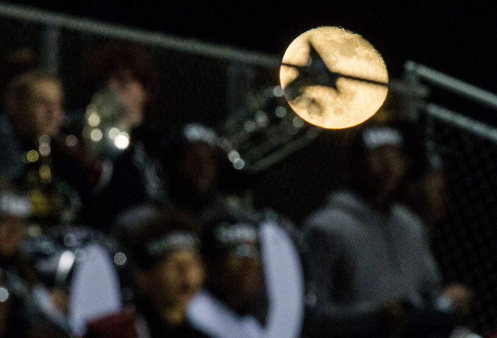 The moon rises over the Mansfield Timberview band during the second quarter of a UIL Class...