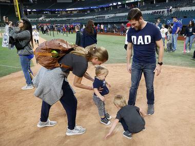 Kristin Jarrett (left) of Grand Prairie helps her son Ryan, 1, to step on home plate while...