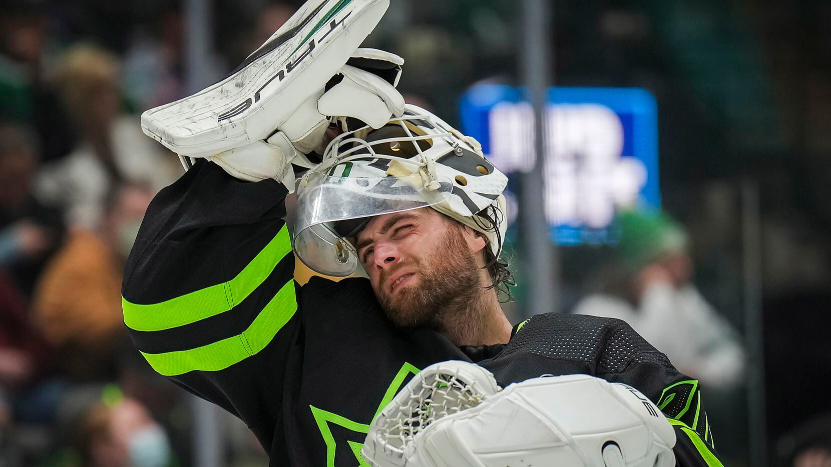Dallas Stars goaltender Braden Holtby adjusts his mask during the second period of an NHL...