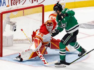 Dallas Stars center Tyler Seguin (91) tries to stick the puck past Calgary Flames goaltender...