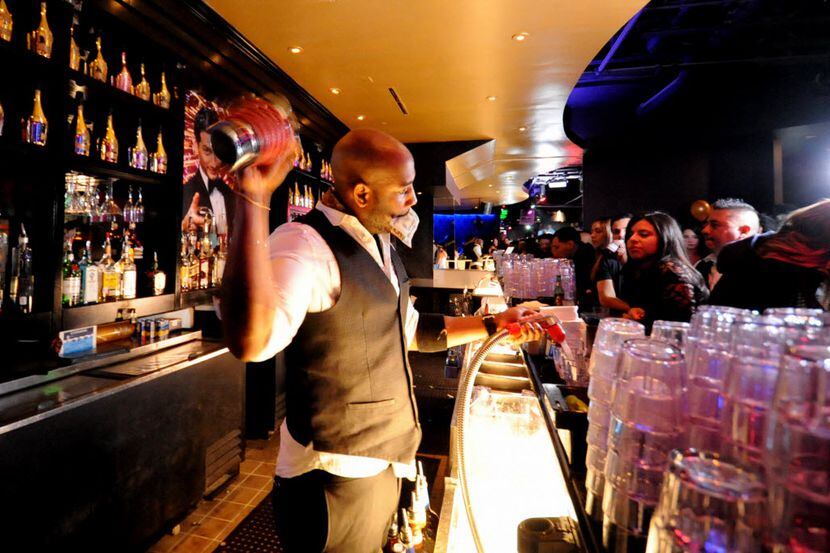 A busy bartender multitasks at the new nightclub Gatsby in Dallas, TX on March 6, 2015. 