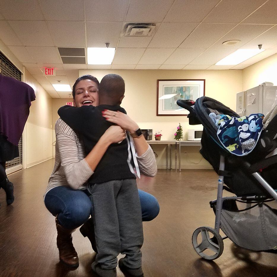 Volunteer Maddy Haas hugs Jamil, a 4-year-old homeless boy whose December birthday was among...