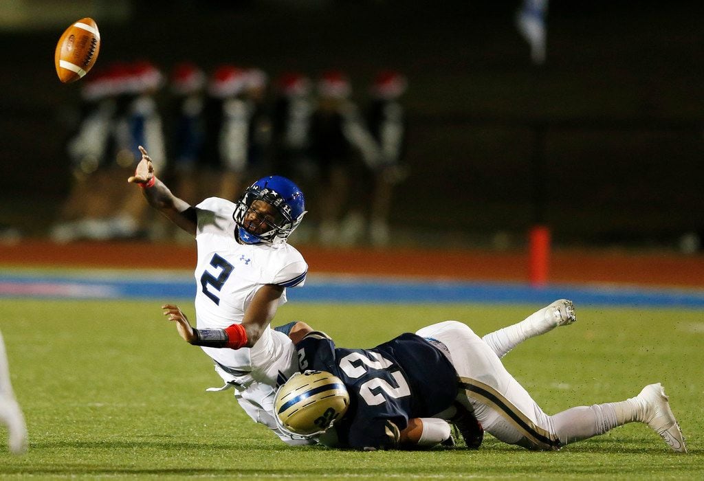 Trinity Christian's Shedeur Sanders (2) gets rid of the ball as Austin Regents Thomas Scully (22) tackles him during the first half of play at the TAPPS Division II State Championship game at Waco Midway's Panther Stadium in Hewitt, Texas on Friday, December 6, 2019. (Vernon Bryant/The Dallas Morning News)