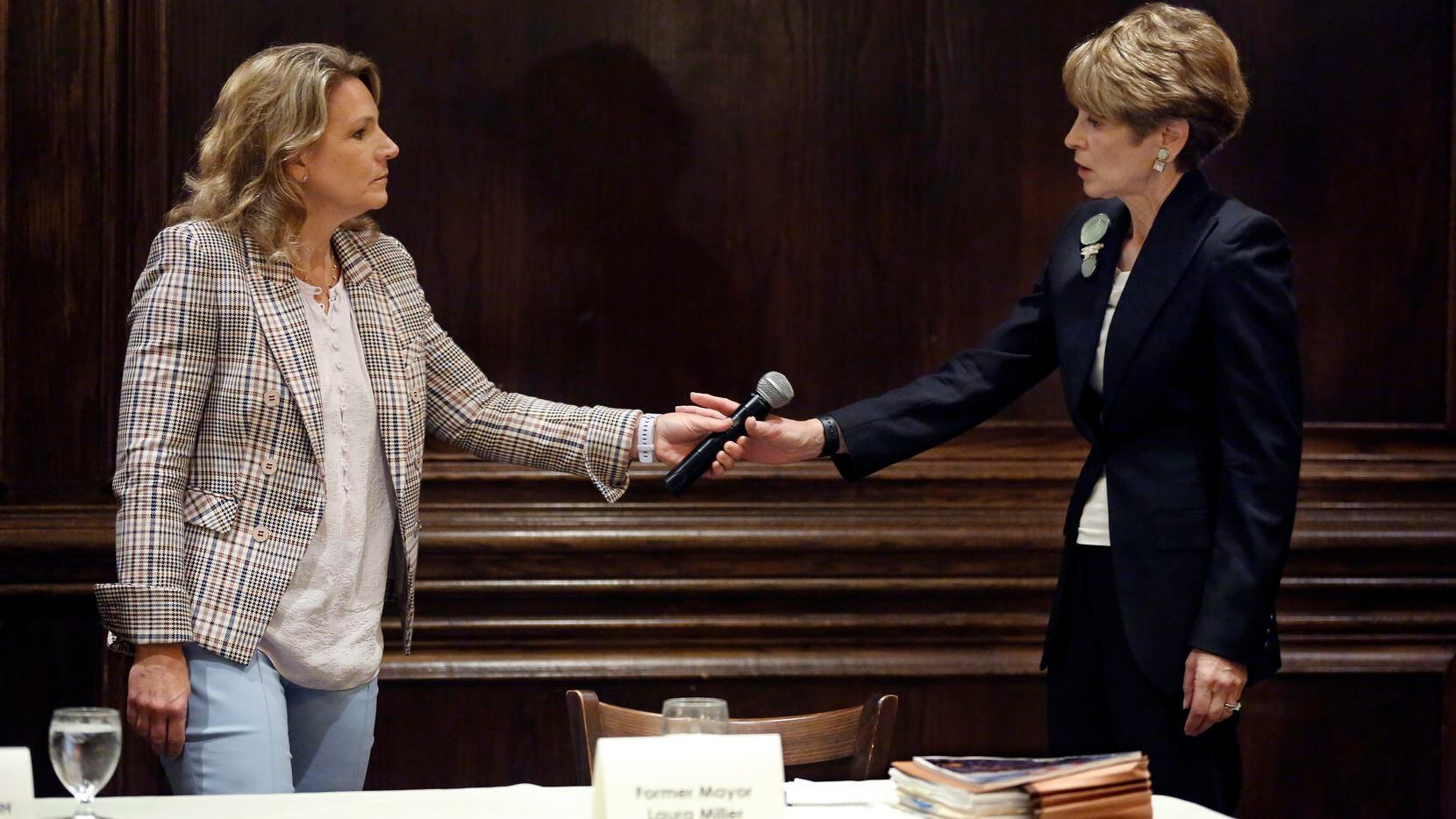 Dallas City Councilwoman Jennifer Staubach Gates (left) hands the microphone to former Dallas Mayor Laura Miller during a debate hosted by Dallas Builders Association at Maggiano's Little Italy - NorthPark in Dallas, Thursday, April 4, 2019. The two are vying for the District 13 seat held by Gates. 