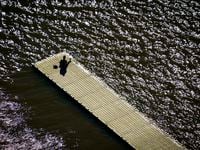 Aerial view of a solitary man sitting on a boat dock at White Rock Lake in Dallas. (Smiley...