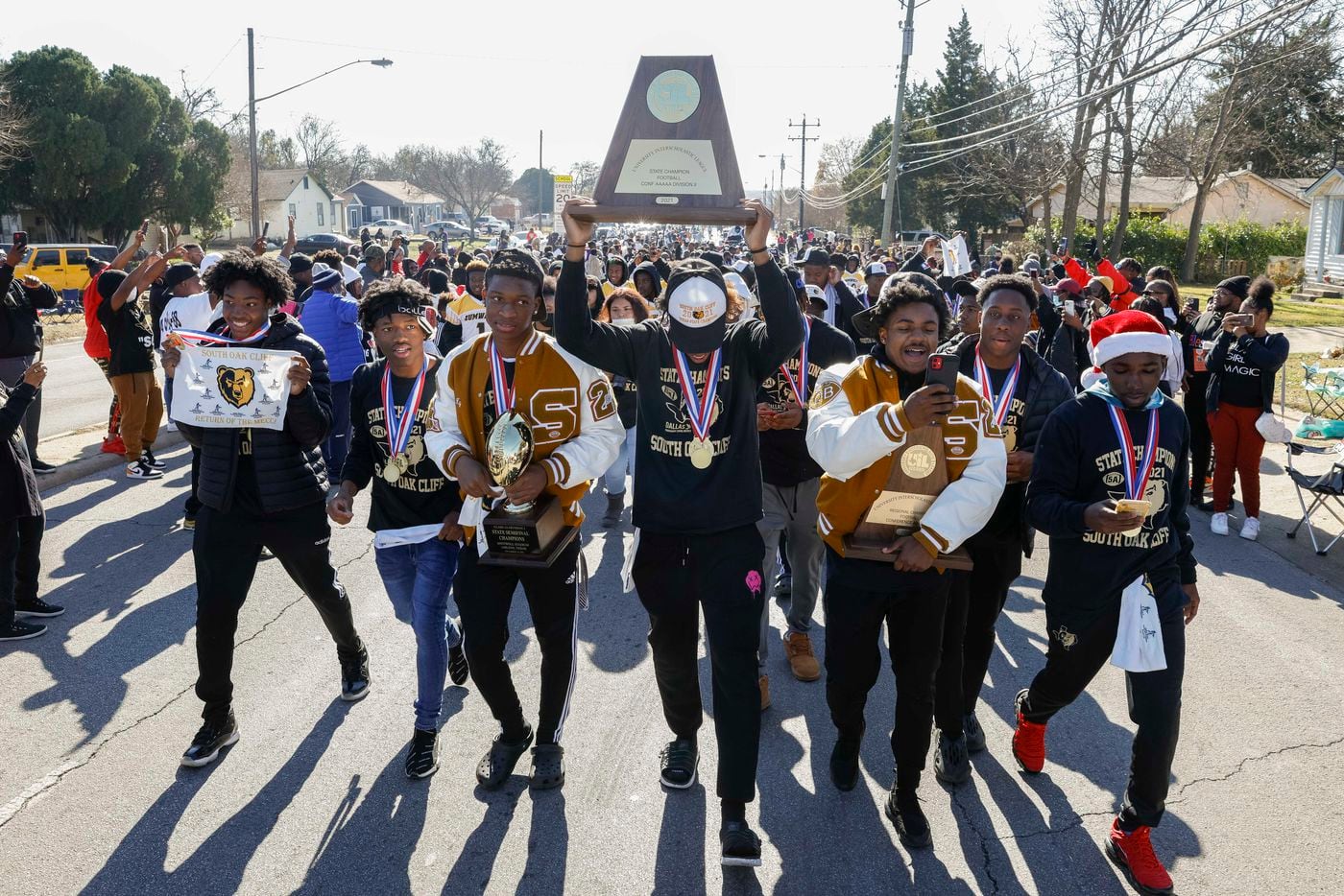 The South Oak Cliff team walks with the state championship trophy during a parade...