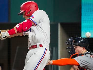 A foul ball off the bat of Texas Rangers second baseman Nick Solak knocks aside the facemask...