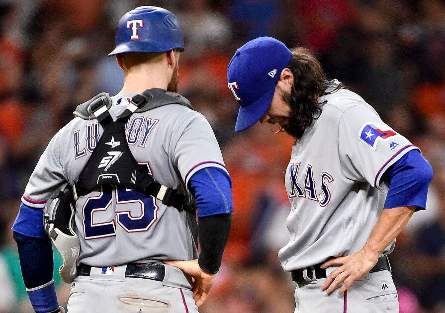 Texas Rangers relief pitcher Tony Barnette, right, looks down before being removed from the...