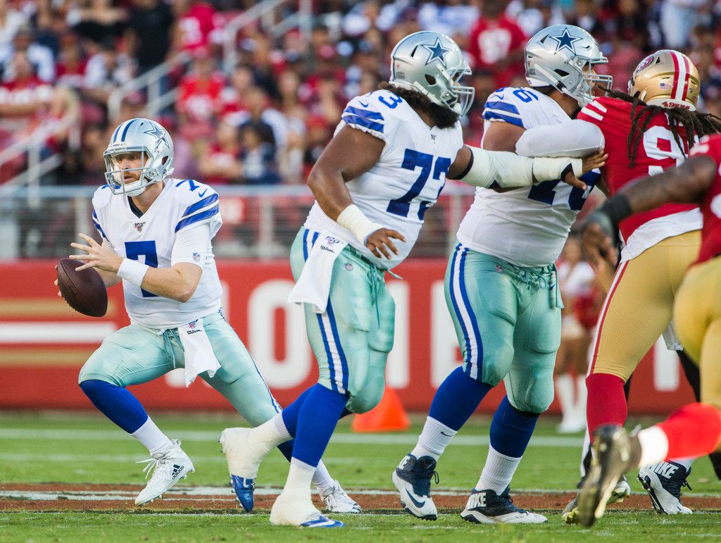 Dallas Cowboys quarterback Cooper Rush (left) scrambles during the second quarter of an NFL...