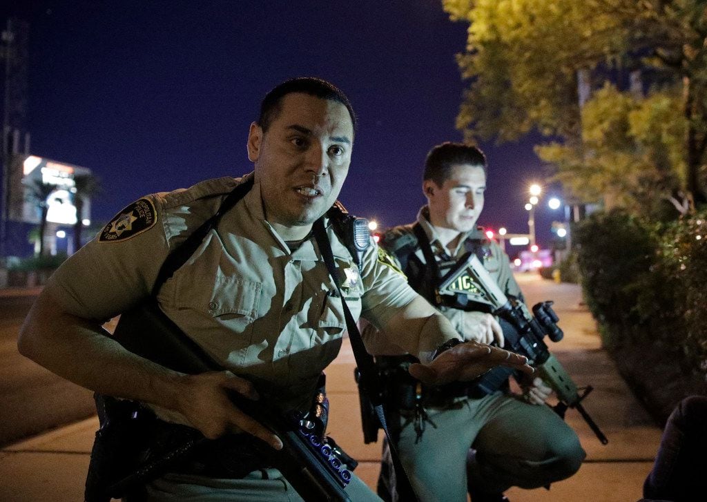 Police advise people to take cover at the scene of a shooting near the Mandalay Bay resort...