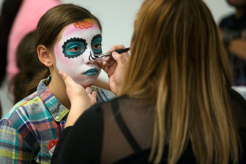 Tiffany Mahan of Dallas gets her face painted during a Dia de los Muertos celebration.