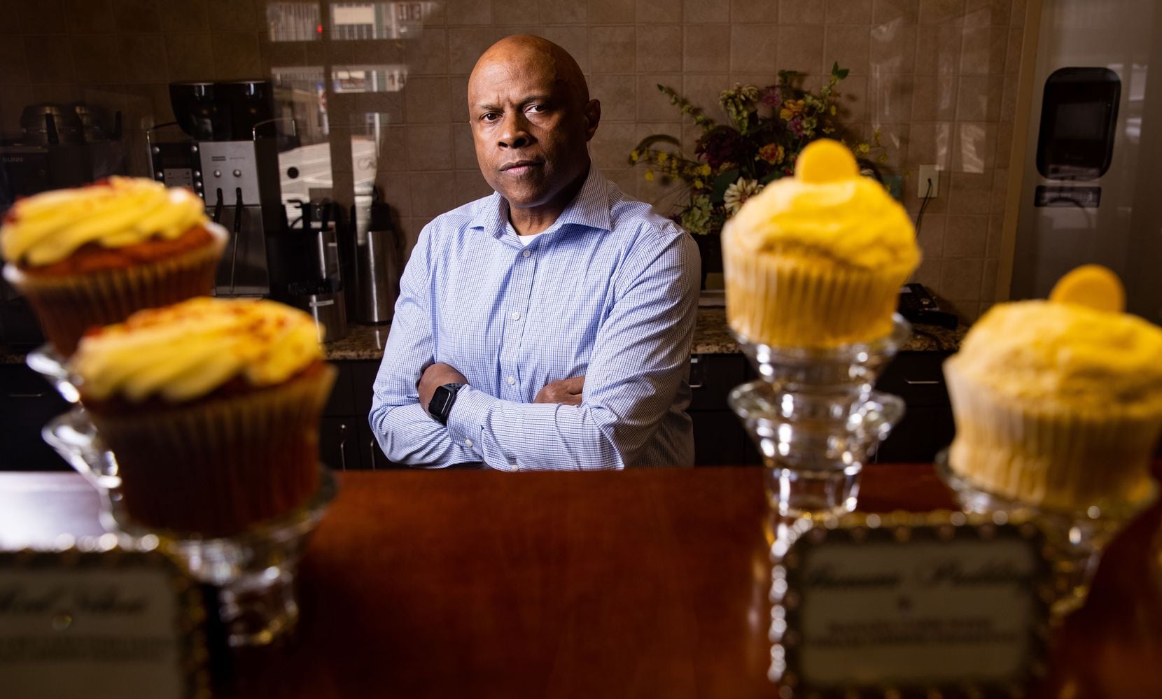 Owner Keith Fluellen posed behind the display counter of Fluellen Cupcakes on May 5 in Dallas. Fluellen Cupcakes, a Black-owned small business, has had to downsize during the pandemic to survive, with Fluellen having to take over chef duties