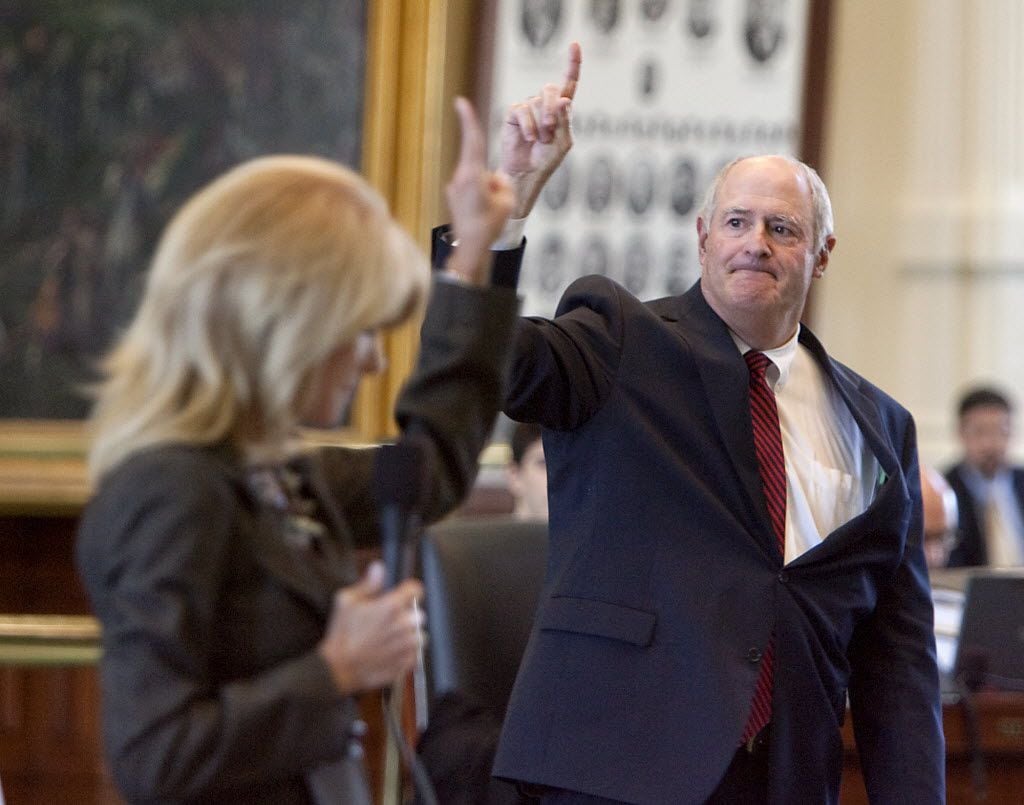 Texas Senators Wendy Davis, D-Fort Worth, left, votes two fingers, nay as Sen. Kel Seliger,...