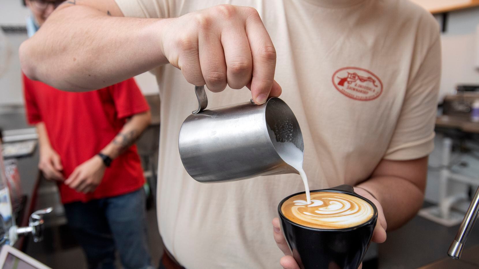 Noah Irby pours milk into a cappuccino at Wayward Coffee, the shop he opened with Trevin...