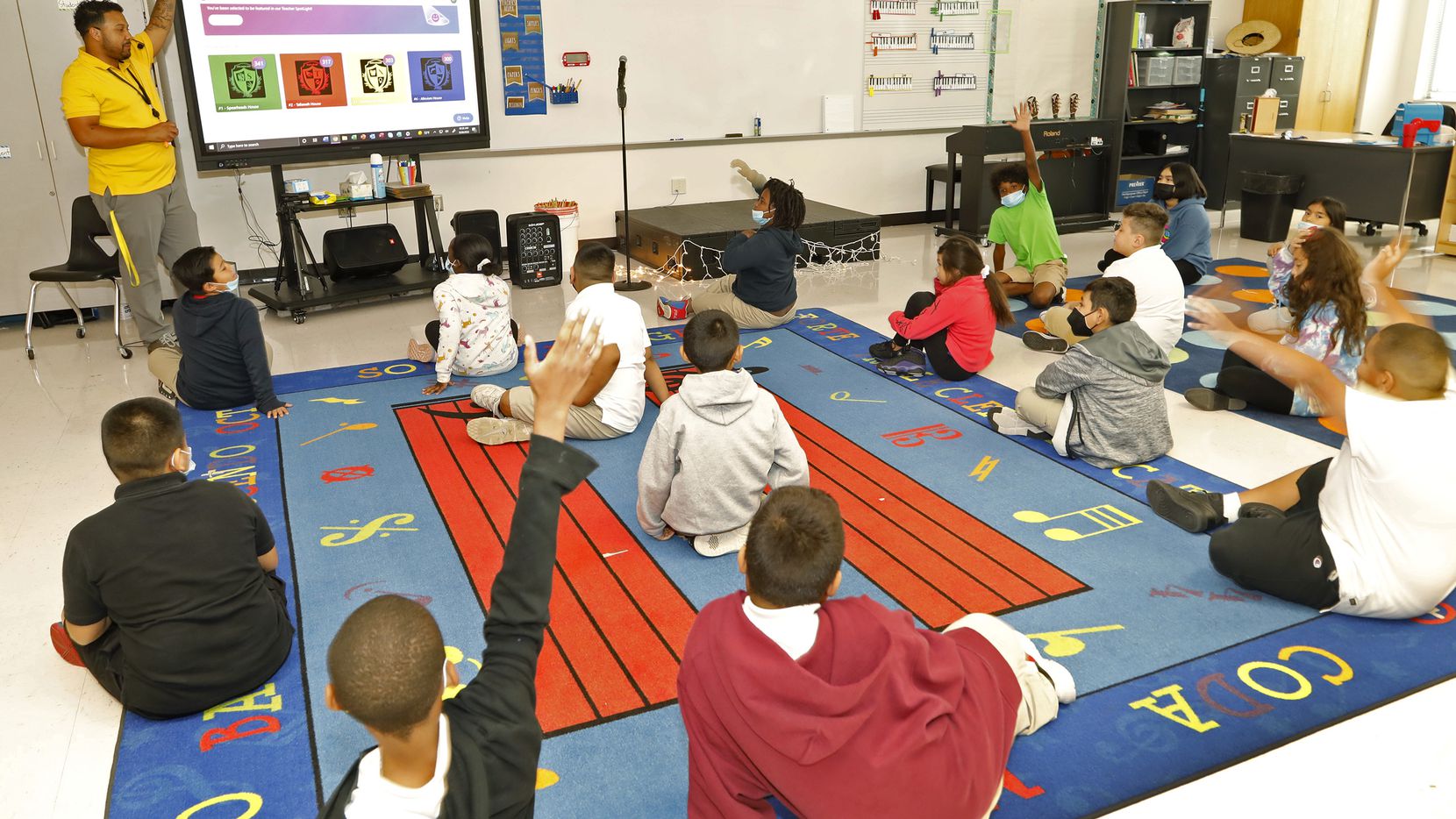 Clyde Forland, a music teacher at Oran M. Roberts Elementary School in Dallas, uses a...