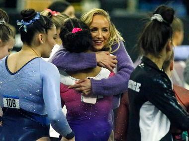 Former Olympic champion Nastia Liuka embraces Konnor McClain after McClain won the overall...