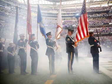 The color guard waits for the smoke to clear so the NFL can honor military members with a...