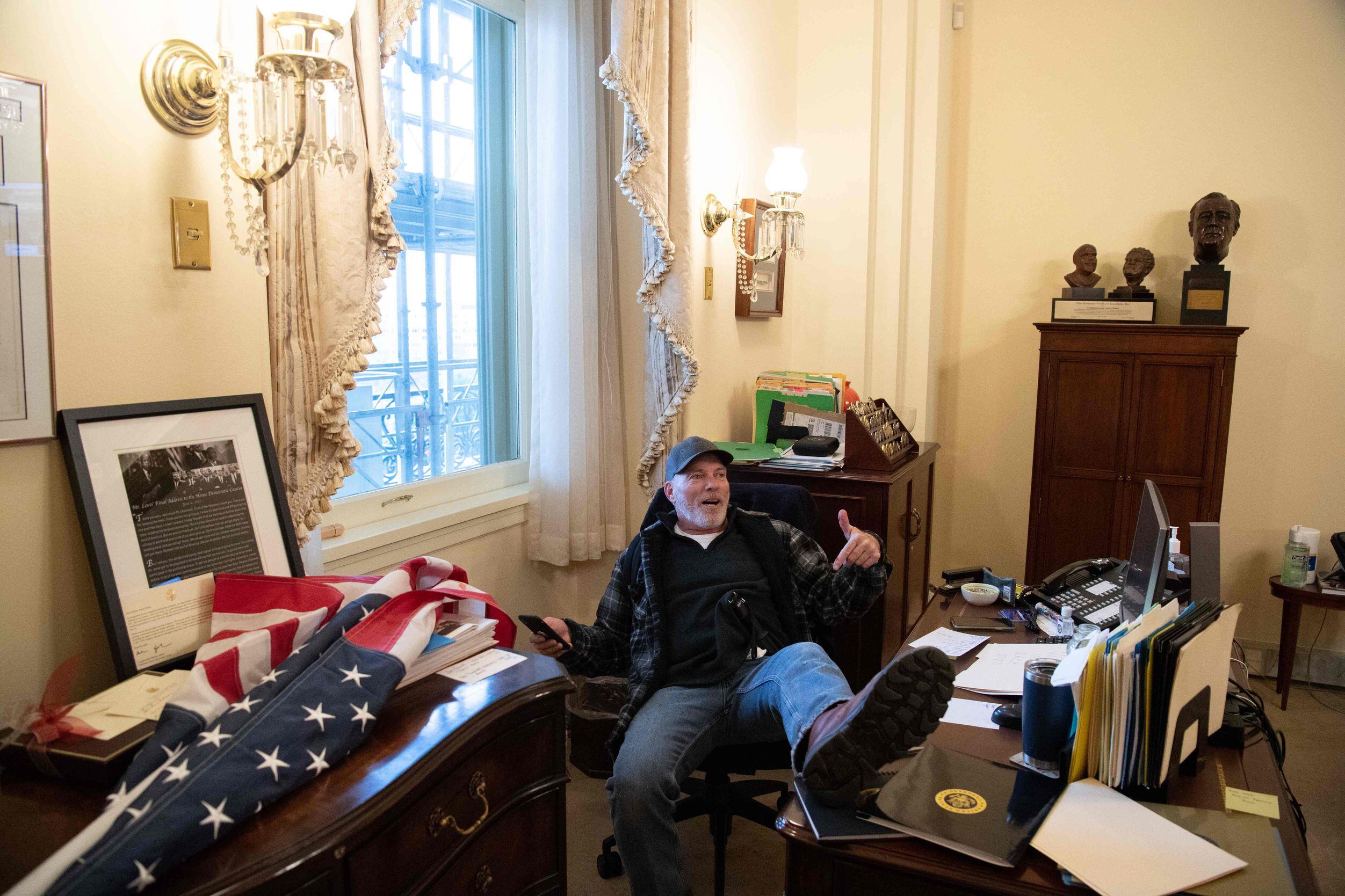 TOPSHOT - A supporter of US President Donald Trump sits inside the office of US Speaker of...