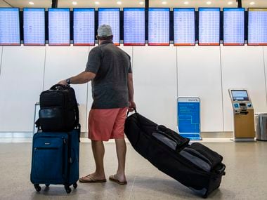 A passenger checked the itineraries for departing flights at DFW Airport's Terminal A on June 21.
