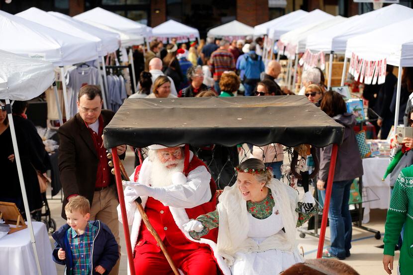 Santa and Mrs. Claus ride in a pony-drawn carriage around the Marche de Noel annual French...