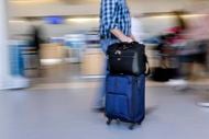 An American Airlines passengers rolls his luggage to check-in in Terminal A at Dallas-Fort...