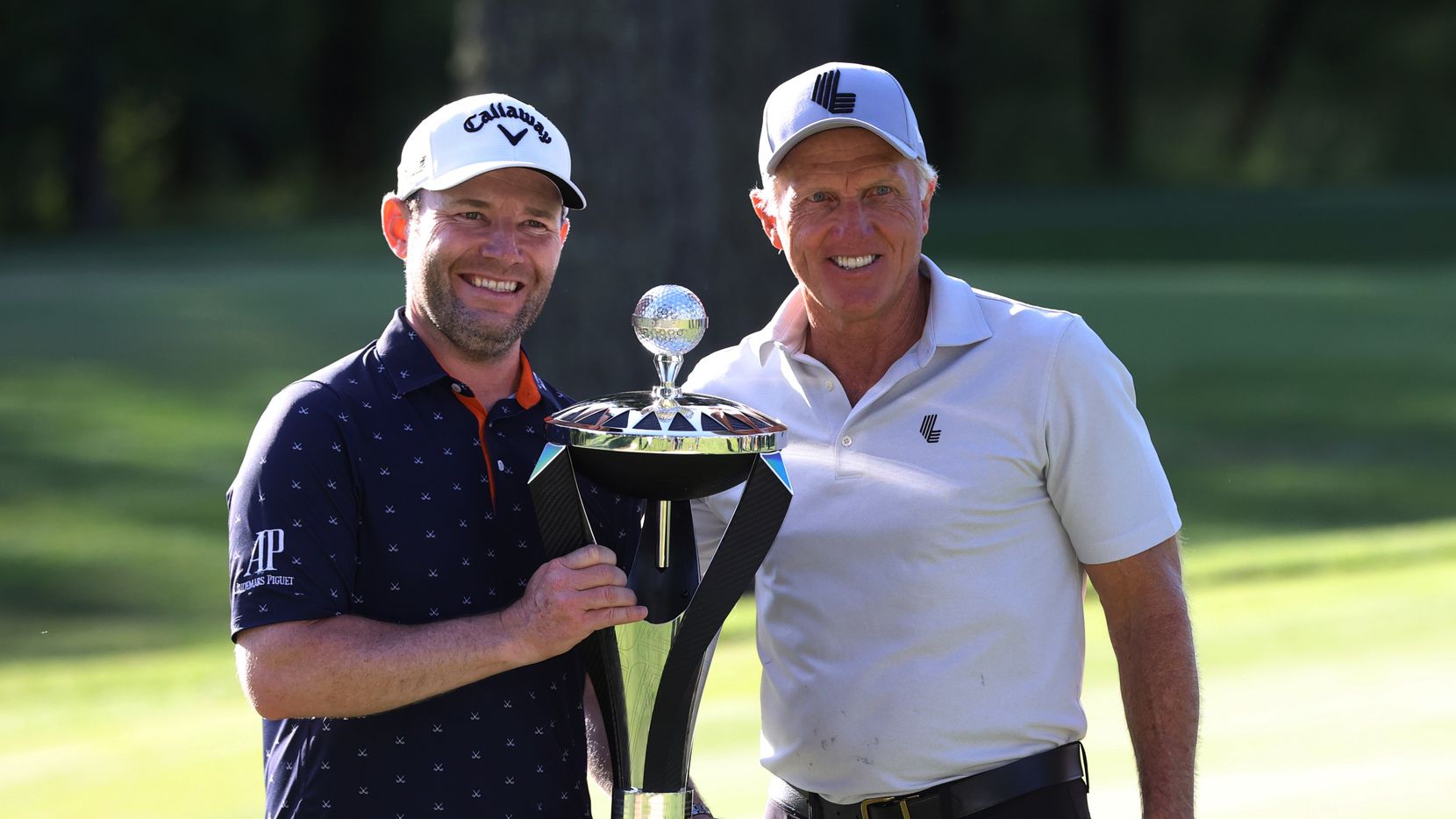 Branden Grace, left, and LIV Golf CEO Greg Norman pose with the trophy after Graze won the...