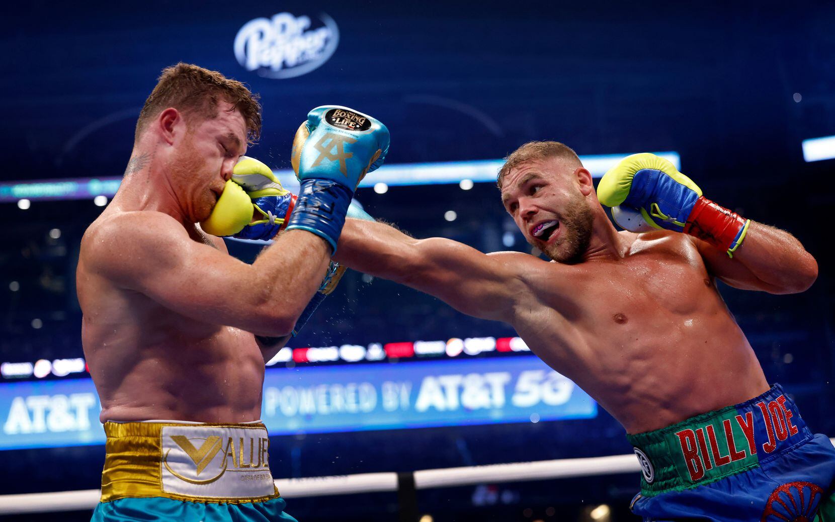 Billy Joe Saunders (right) got a clean shot to the face of Canelo Alvarez during their super middleweight title fight in Arlington. Alvarez won with an eighth-round TKO victory. The event was reminiscent of what live sports were like before the pandemic.